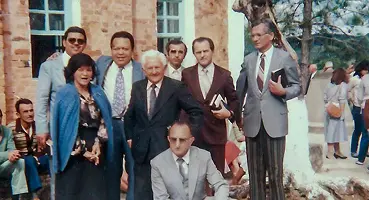 Foto colorida de um grupo de líderes e o Rev. Willes Banks Leite, posando formalmente com Bíblias na mão.